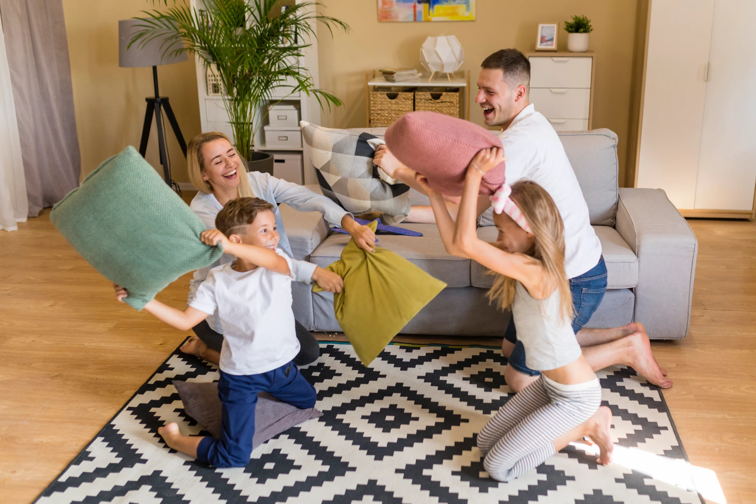 Maid-Housekeeping-Family-Wellness-Benefits maid housekeeping family wellness. Happy family enjoying time together in a clean living room after maid service
